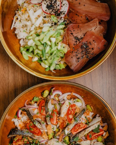 Two colorful poke bowls with fresh toppings.