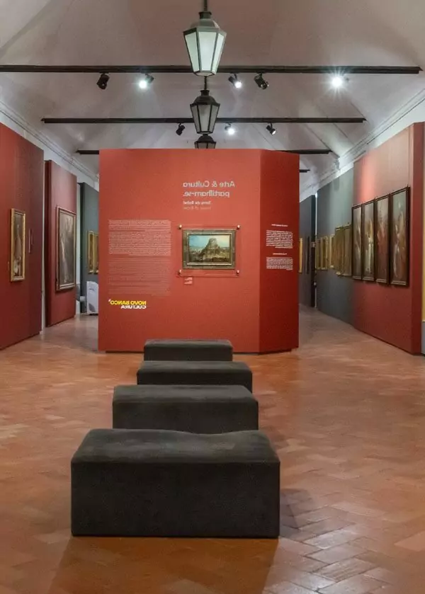 Art gallery exhibition with paintings and benches.