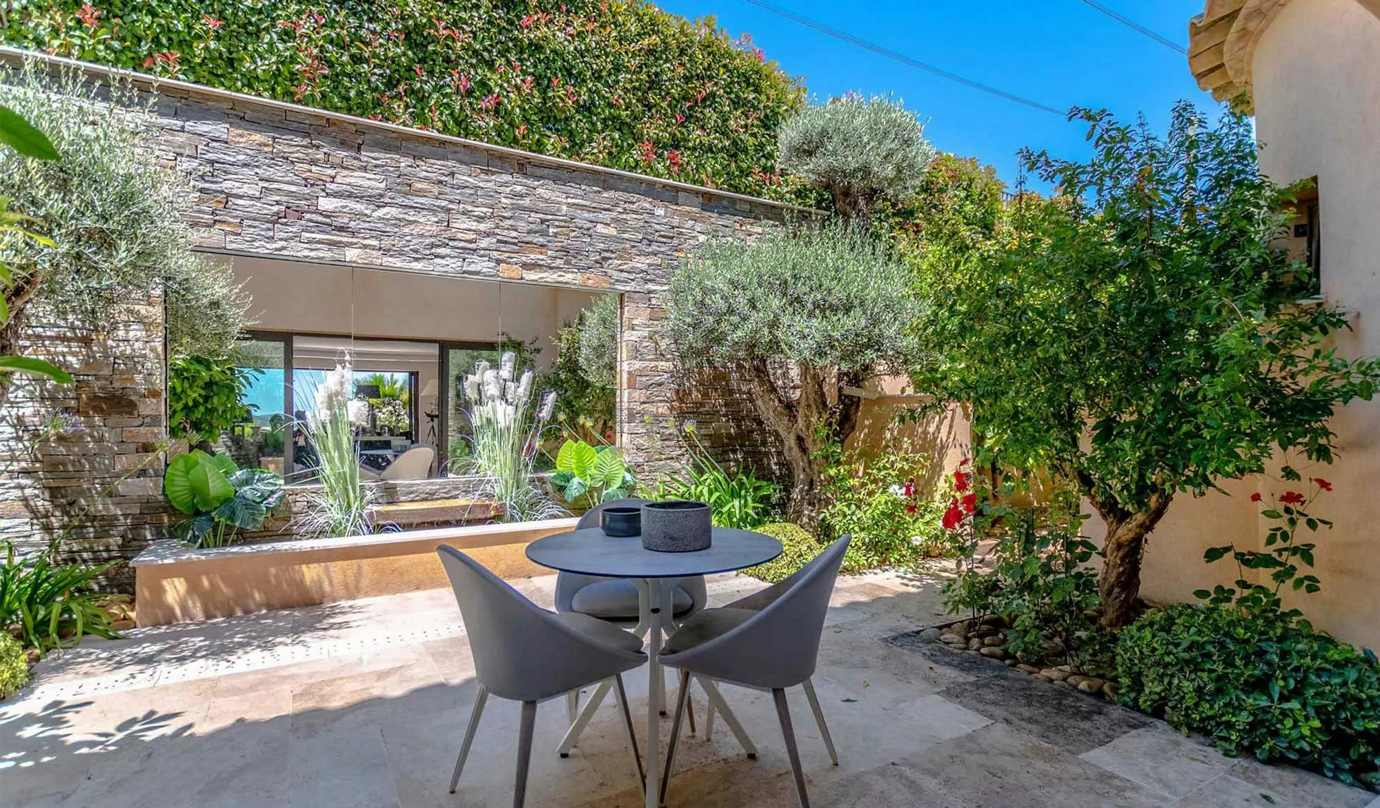 Outdoor patio with table and chairs in a lush garden