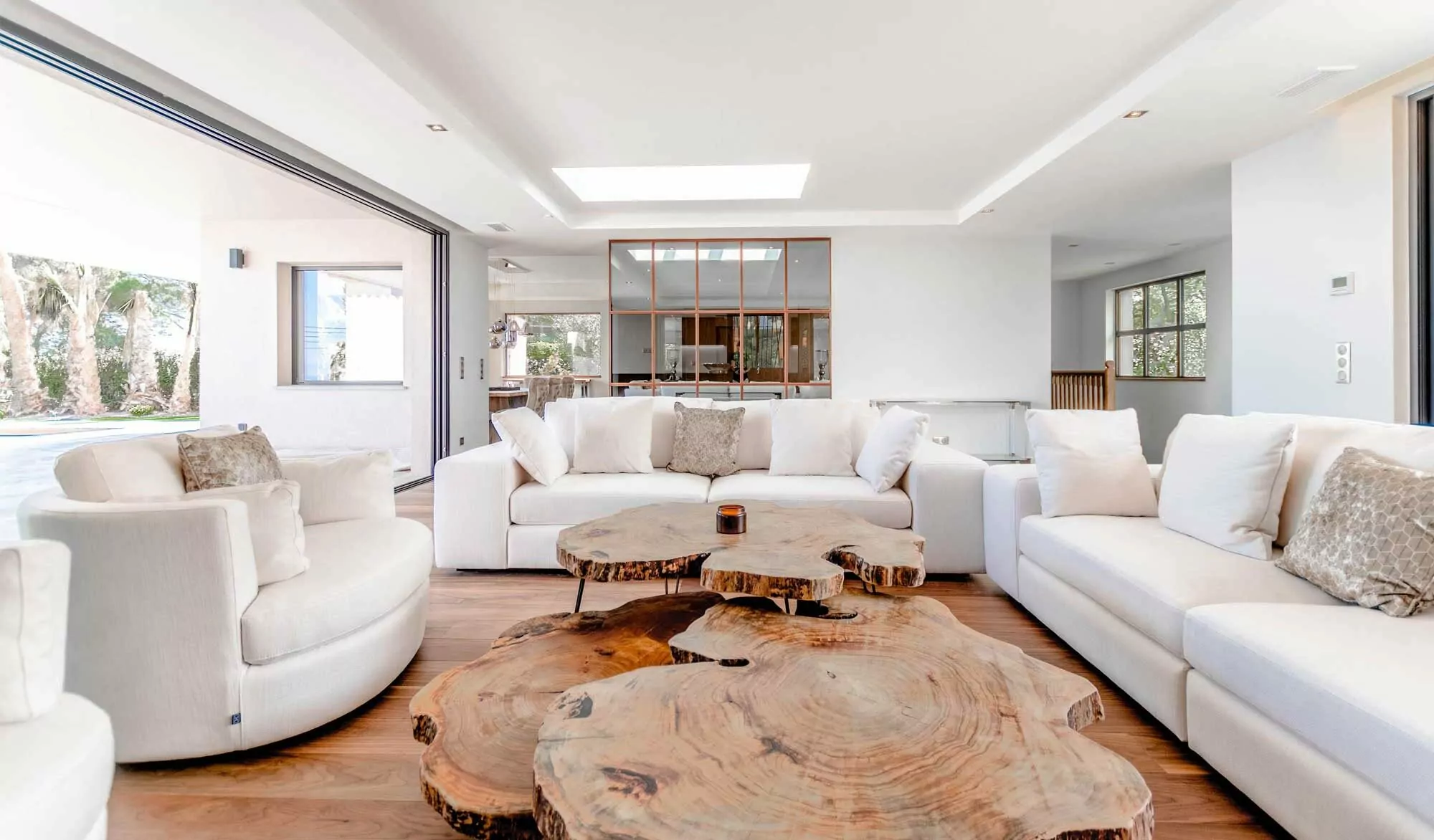 Spacious living room with white sofas and wood table.